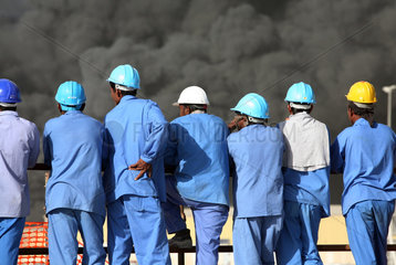 Dubai  VAE  Bauarbeiter blicken auf eine schwarze Rauchwolke