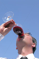 man drinking red vine