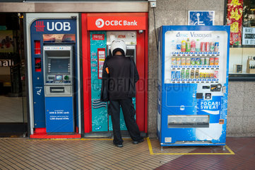 Singapur  Republik Singapur  Ein Mann hebt an einem Geldautomaten Geld ab