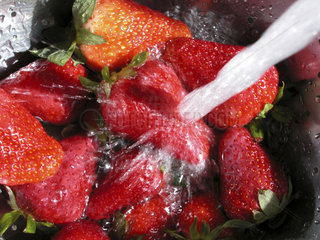 Wasserstrahl l__uft auf Erdbeeren