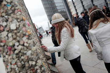 Berlin  Deutschland  Touristen bekleben die Mauerreste am Potsdamer Platz mit Kaugummis