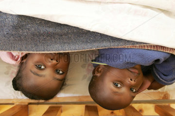 Kenia  eine Gruppe von Kindern liegt zugedeckt in einem Kinderbett