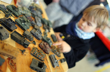 Berlin  Deutschland  Junge schaut sich Kriegsspielzeug an