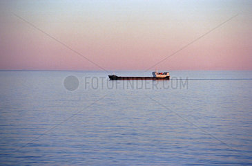 Ein Frachter auf der Ostsee bei Sonnenaufgang  Polen