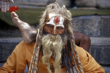 hinduistischer Geistlicher mit Fuss hinter seinem Kopf