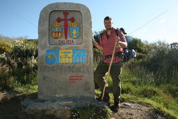 Pilger neben Eingangsschild der Provinz Galicien am Jakobsweg