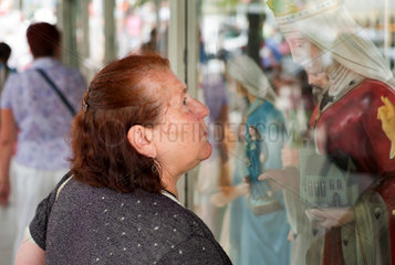 Tschenstochau  Polen  Frau betrachtet ein Schaufenster eines Devotionaliengeschaeftes
