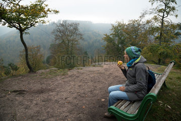 Frankreich  Wanderin bei einer Pause auf einer Bank im Regionaler Naturpark Nordvogesen  Elsass