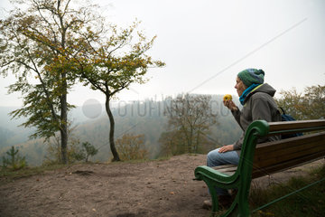 Frankreich  Wanderin bei einer Pause auf einer Bank im Regionaler Naturpark Nordvogesen  Elsass