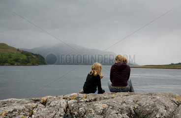 Ratagan  Grossbritannien  Mutter und Tochter sitzen am Ufer des Loch Duich