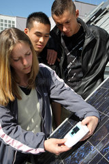 Berlin  Deutschland  Auszubildende messen Solarstrom eines Solar-Panels