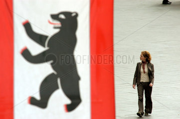 Frau neben einer Flagge mit dem Berliner Baeren