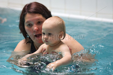 Berlin  Deutschland  Frau mit Kind beim Babyschwimmen