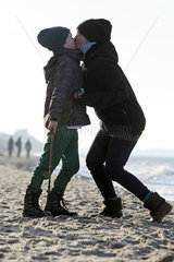 Meschendorf  Deutschland  Mutter kuesst ihren Sohn bei einem Spaziergang am Strand