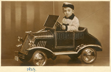 Junge mit seinem neuen Tretauto  1937