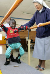 Kenia  ein behinderter Junge uebt gehen