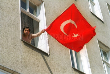 Mann haelt die tuerkische Flagge aus dem Fenster  Berlin