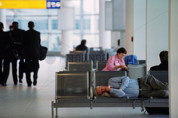 Schlafender Tourist in einer Wartehalle auf dem Flughafen in Prag  Tschechien