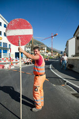 Samedan  Schweiz  Bauarbeiter regelt den Verkehr einer Strassenbaustelle