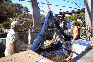 Cala Figuera  Fischer saeubern ein Fischernetz