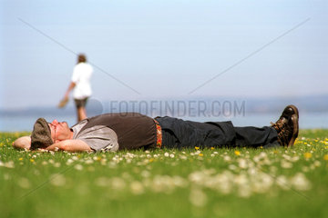 Mann bei einem Nickerchen am Bodensee  Schweiz