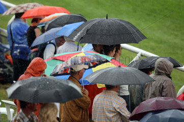 Hamburg  Deutschland  Menschen stehen bei Schlechtwetter unter ihren Regenschirmen