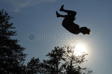 Briescht  Deutschland  Silhouette  Junge schlaegt einen Salto in der Luft