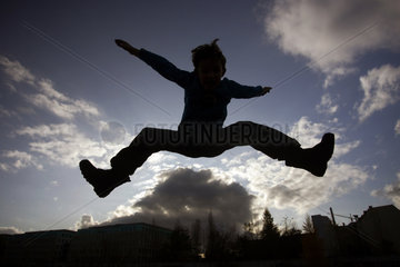 Berlin  Deutschland  Silhouette  Junge macht einen Spagat in der Luft