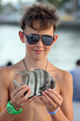 Pass a Grille Beach  USA  Junge zeigt stolz seinen geangelten Fisch