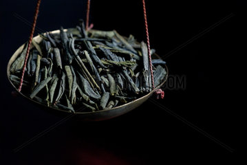 Berlin  Deutschland  Teeblaetter des gruenen Tees Liu An Gua Pian auf einer Waage
