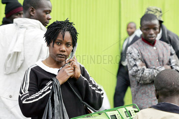 Nairobi  junge Frau telefoniert von einem oeffentlichen Telefon aus