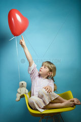 Berlin  Deutschland  ein Maedchen mit einem herzfoermigen Luftballon