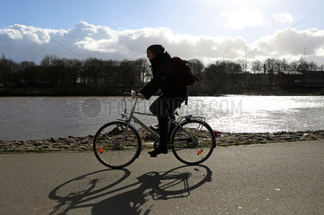 Bremen  Deutschland  Silhouette  Fahrradfahrerin radelt entlang der Weser