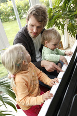 Hamburg  Deutschland  Vater und Kinder spielen Klavier