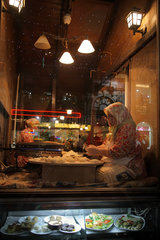 Istanbul  Tuerkei  Frau im Schaufenster bei der Zubereitung von Fladenbrot