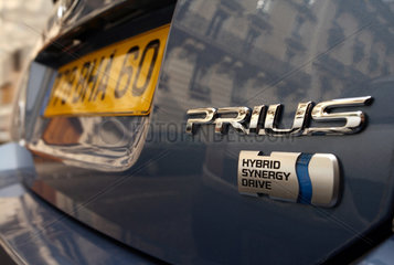Symbolfoto  Logo eines Toyota Prius mit Hybrid Antrieb
