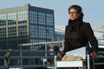 Hamburg  Deutschland  Geschaeftsfrau mit einem Macbook Pro im Kofferkuli