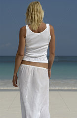 Junge Frau geht am Strand spazieren  Bahamas
