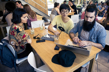 Man using laptop computer while companions watch