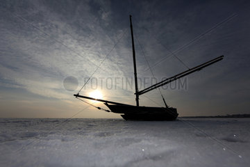 Wustrow  Deutschland  Silhouette  Segelboot liegt auf der zugefrorenen Ostsee