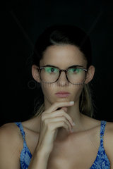 Young woman wearing glasses  deep in thought  portrait
