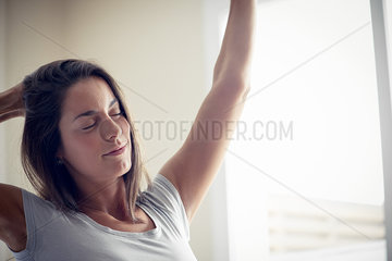 Young woman waking up in morning