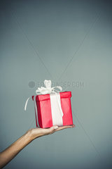 Woman's hand holding wrapped gift