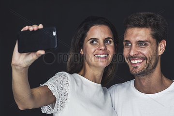 Couple using smartphone to take a selfie