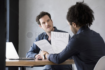 Men reviewing and discussing document