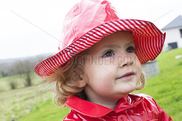 Little girl in wearing rain hat and raincoat