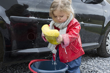 Little girl washing car