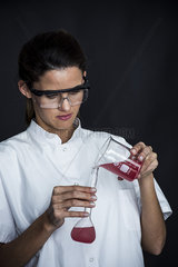 Laboratory technician pouring liquid into flask