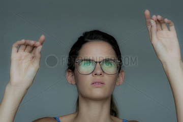Young woman gesturing as if using touch screen technology
