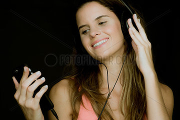 Young woman using smartphone and listening to headphones